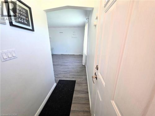 Interior entryway featuring wood-finish flooring, white walls, and an arched doorway - 353 East 21St Street, Hamilton, ON - Indoor Photo Showing Other Room