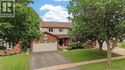 Brick facade two-story residence with an attached garage and asphalt driveway - 