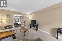 Carpeted living area with neutral wall tones and white baseboards - 