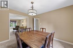 Dining area featuring a decorative ceiling light fixture, neutral wall color, and carpeted flooring - 
