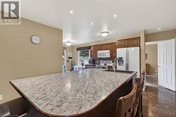 Spacious kitchen island featuring a light-toned countertop, integrated sink with gooseneck faucet, and dark wood-finish base - 