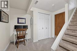Carpeted staircase with white handrail, leading to a space featuring a bi-fold closet with paneled doors and a solid wood door - 