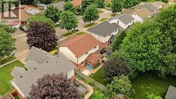 Residential neighborhood featuring a variety of roof styles and mature trees - 