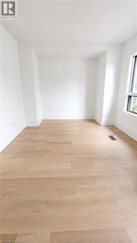 Light wood-finish flooring, recessed lighting, and a large window providing natural illumination - 561 Wentworth Street N, Hamilton, ON - Indoor Photo Showing Other Room