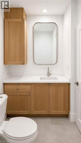 White countertop vanity with wood-finish cabinetry and an integrated sink - 561 Wentworth Street N, Hamilton, ON - Indoor Photo Showing Bathroom