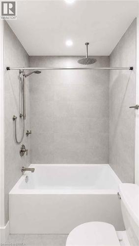 Modern bathroom featuring a soaking tub with frameless glass shower enclosure, dual showerheads including an overhead rainfall fixture, chrome fixtures, light-filled recessed ceiling lighting, and neu - 561 Wentworth Street N, Hamilton, ON - Indoor Photo Showing Bathroom