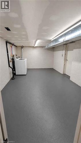 Expansive unfinished basement featuring painted concrete flooring, exposed utility piping, and fluorescent lighting - 561 Wentworth Street N, Hamilton, ON - Indoor