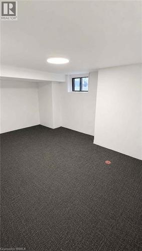Recessed window, white painted walls, ceiling-mounted light fixture, and dark patterned carpet flooring - 561 Wentworth Street N, Hamilton, ON - Indoor