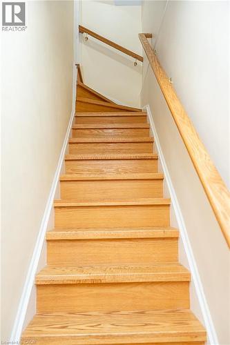 Solid wood staircase with natural finish and white risers, featuring dual wood handrails - 41 Paradise Road S, Hamilton, ON - Indoor Photo Showing Other Room