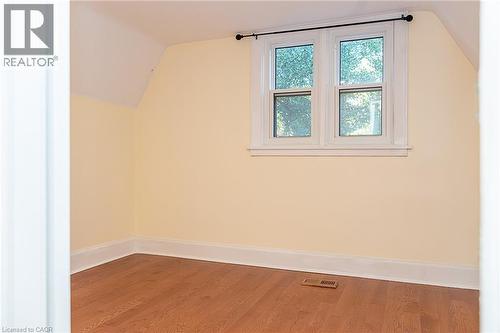 Hardwood-finish flooring, white window trim, and sloped ceiling - 41 Paradise Road S, Hamilton, ON - Indoor Photo Showing Other Room