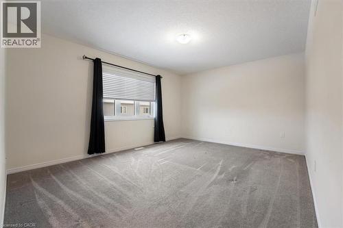 Carpeted spare room featuring a textured ceiling and baseboards - 13 Steven Drive, Thorold, ON - Indoor Photo Showing Other Room