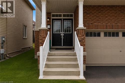 Brick facade with a covered porch featuring white columns and railings - 13 Steven Drive, Thorold, ON - Outdoor With Exterior