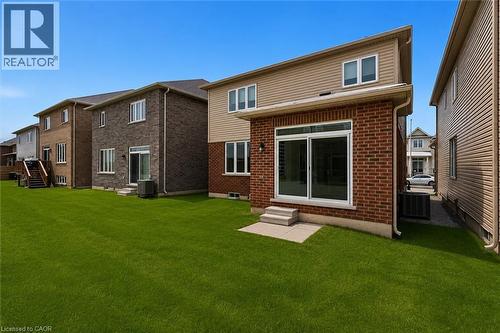 Expansive green lawn with a two-story residence featuring a brick and siding exterior - 13 Steven Drive, Thorold, ON - Outdoor With Exterior