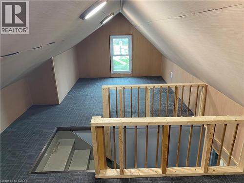 Loft space featuring sloped ceilings, a window, track lighting, and wood railings - 49 West Avenue, Kitchener, ON - Indoor Photo Showing Other Room