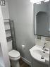 White ceramic toilet with wood-finish flooring - 49 West Avenue, Kitchener, ON  - Indoor Photo Showing Bathroom 