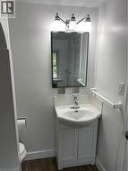 Vanity with integrated sink, chrome faucet, white subway tile backsplash, framed mirror, and chrome-finish lighting fixture - 