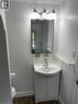 Vanity with integrated sink, chrome faucet, white subway tile backsplash, framed mirror, and chrome-finish lighting fixture - 49 West Avenue, Kitchener, ON  - Indoor Photo Showing Bathroom 