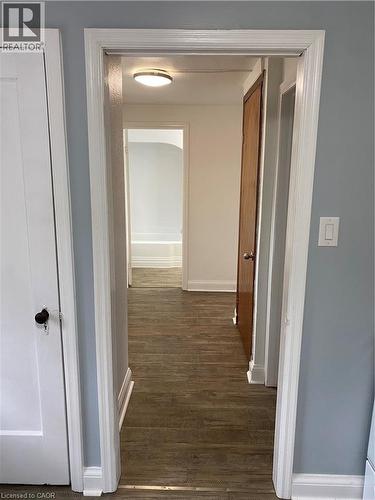 Wood-finish flooring throughout, white trim, and light blue walls - 49 West Avenue, Kitchener, ON - Indoor Photo Showing Other Room