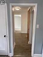 Wood-finish flooring throughout, white trim, and light blue walls - 