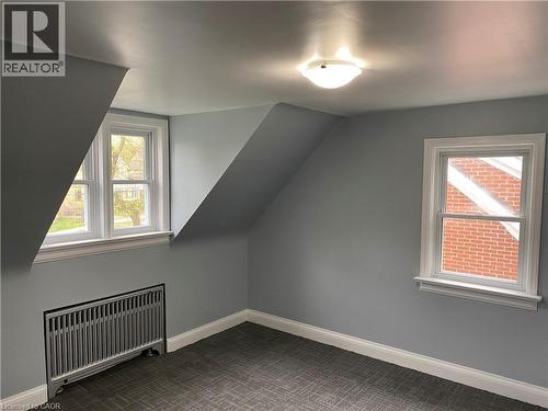 Room featuring two double-hung windows, sloped ceilings, a flush mount ceiling light fixture, and wall-to-wall carpeting - 49 West Avenue, Kitchener, ON - Indoor Photo Showing Other Room