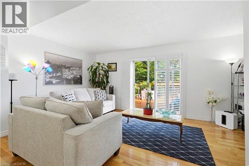 Hardwood flooring throughout, sliding glass door with white shutters, and a rear wood deck - 145 Rice Avenue Unit# 2, Hamilton, ON - Indoor Photo Showing Living Room