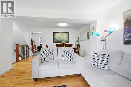 Hardwood flooring throughout, recessed lighting, white walls, dark wood and wrought iron staircase, and an open concept layout - 145 Rice Avenue Unit# 2, Hamilton, ON - Indoor Photo Showing Living Room