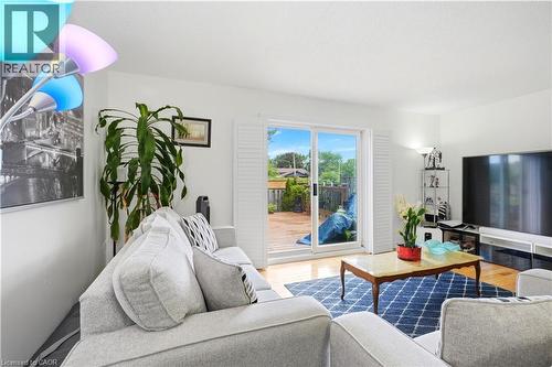 Hardwood flooring, sliding glass door, white interior walls, white window shutters, and a rear deck - 145 Rice Avenue Unit# 2, Hamilton, ON - Indoor Photo Showing Living Room