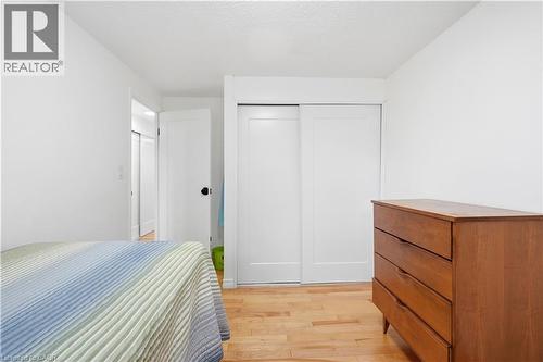 Wood-finish flooring, white walls, and a white sliding closet door - 145 Rice Avenue Unit# 2, Hamilton, ON - Indoor Photo Showing Bedroom