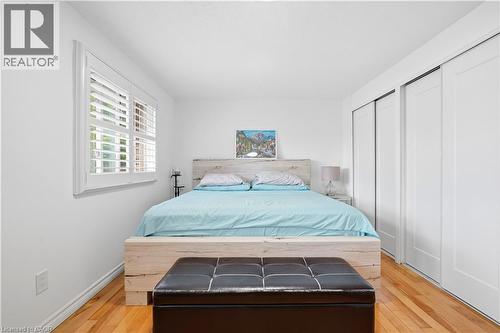 Wood-finish flooring, white plantation shutters, and white bi-fold closet doors - 145 Rice Avenue Unit# 2, Hamilton, ON - Indoor Photo Showing Bedroom