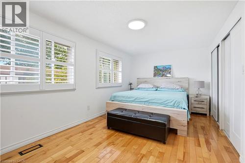 Hardwood flooring, white wall paint, window shutters, recessed lighting, and sliding closet doors - 145 Rice Avenue Unit# 2, Hamilton, ON - Indoor Photo Showing Bedroom