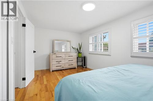 Hardwood flooring, white walls, and bright windows with white plantation shutters - 145 Rice Avenue Unit# 2, Hamilton, ON - Indoor Photo Showing Bedroom