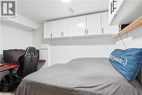 White wall-mounted cabinetry with matte black hardware, integrated ceiling light, and built-in shelving - 145 Rice Avenue Unit# 2, Hamilton, ON - Indoor Photo Showing Bedroom