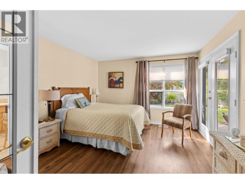Bright primary bedroom with doors to outside private yard. - 4000 Gallaghers Terrace, Kelowna, BC - Indoor Photo Showing Bedroom