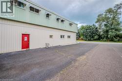Commercial or industrial building featuring a two-tone metal exterior with upper green corrugated panels and lower cream-colored siding - 