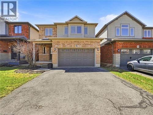 Traditional-style residence featuring a combination of brick and siding exterior, an attached garage, a covered front porch, and a paved driveway - 98 Willow Lane, Grimsby, ON - Outdoor With Facade