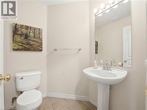 Pedestal sink with chrome faucet, large vanity mirror, and globe light fixture - 98 Willow Lane, Grimsby, ON - Indoor Photo Showing Bathroom