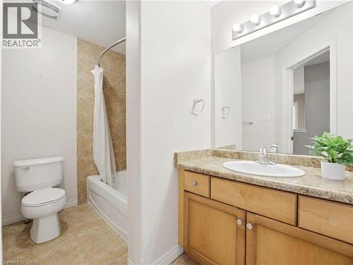 Full bathroom featuring a single vanity with a laminate countertop, light wood-finish cabinetry, and a full-width mirror - 98 Willow Lane, Grimsby, ON - Indoor Photo Showing Bathroom