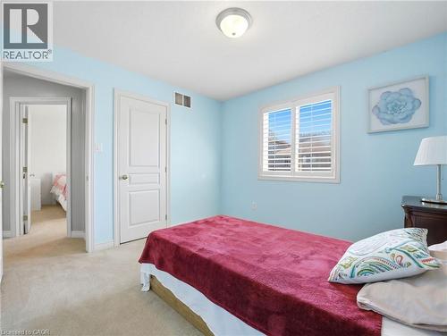 Light blue painted interior room with neutral carpet flooring - 98 Willow Lane, Grimsby, ON - Indoor Photo Showing Bedroom