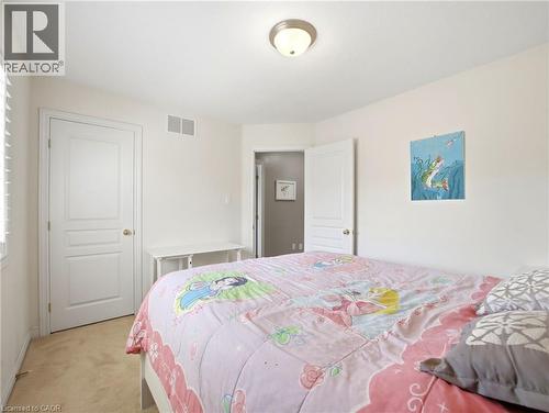 Carpeted bedroom featuring a white paneled door, a window with horizontal blinds, and a flush mount ceiling light - 98 Willow Lane, Grimsby, ON - Indoor Photo Showing Bedroom