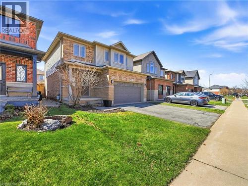 Two-story residence featuring a mixed-material facade with brick and siding, an attached single-car garage, and a paved driveway - 98 Willow Lane, Grimsby, ON - Outdoor