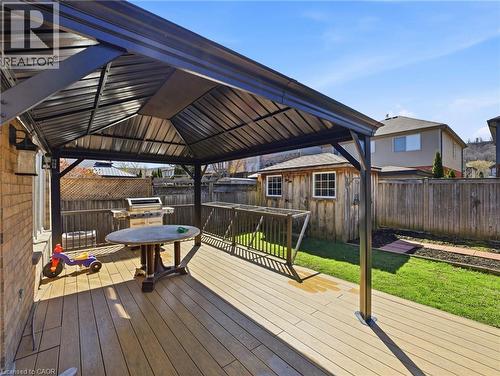 Expansive rear deck featuring wood-finish composite decking under a dark metal gazebo - 98 Willow Lane, Grimsby, ON - Outdoor With Deck Patio Veranda With Exterior