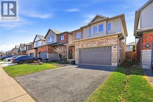 Two-story residence featuring a combination of brick and siding exterior, an attached garage with a dual-width door, and an asphalt driveway - 98 Willow Lane, Grimsby, ON - Outdoor With Facade