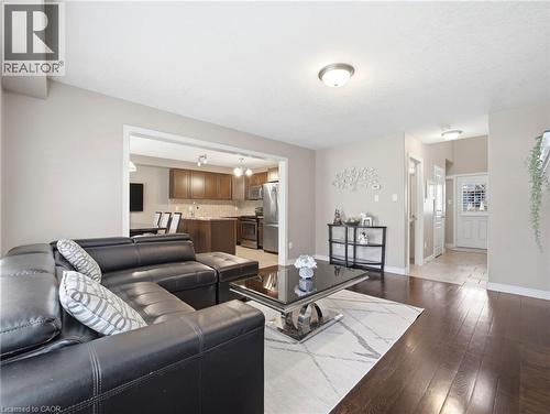 Open-concept living space featuring rich wood-finish flooring, recessed lighting, and a neutral color palette - 98 Willow Lane, Grimsby, ON - Indoor Photo Showing Living Room