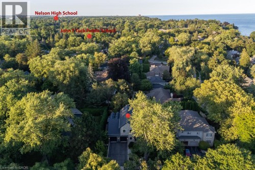 Aerial perspective showcasing a residential area with extensive tree coverage and a visible body of water - 253 Rossmore Boulevard, Burlington, ON - Outdoor With Body Of Water With View