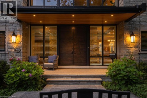 Stone facade with exterior sconce lighting, wood soffit, and recessed lighting - 253 Rossmore Boulevard, Burlington, ON - Outdoor