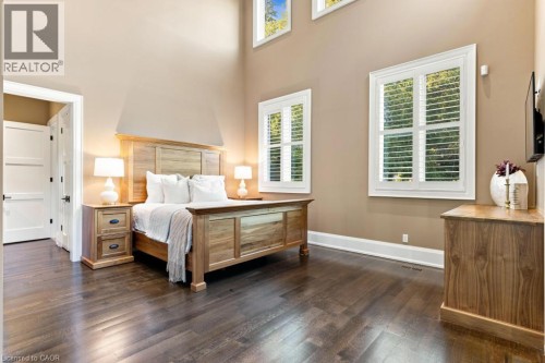 Dark wood-finish flooring with high ceilings and white trim - 253 Rossmore Boulevard, Burlington, ON - Indoor Photo Showing Bedroom