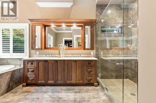 Dual vanity with wood-finish cabinetry, integrated mirrors, and sconce lighting - 253 Rossmore Boulevard, Burlington, ON - Indoor Photo Showing Bathroom