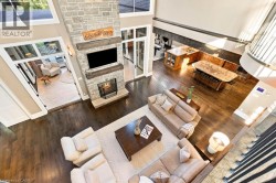 Soaring ceilings and dark wood-finish flooring define this open-concept living space - 