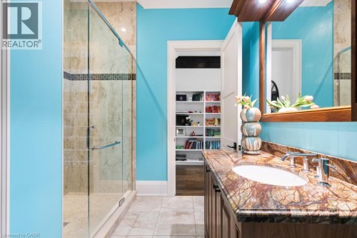 Walk-in shower with natural stone tile, glass enclosure, and decorative accent band - 253 Rossmore Boulevard, Burlington, ON - Indoor Photo Showing Bathroom