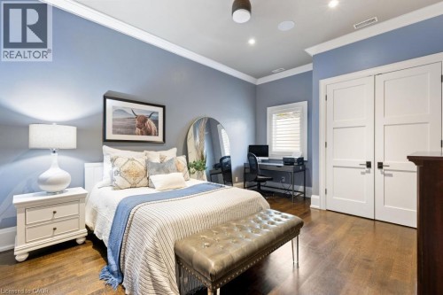 Hardwood flooring, recessed lighting, white crown molding, white doors with dark hardware, and a window with white blinds - 253 Rossmore Boulevard, Burlington, ON - Indoor Photo Showing Bedroom